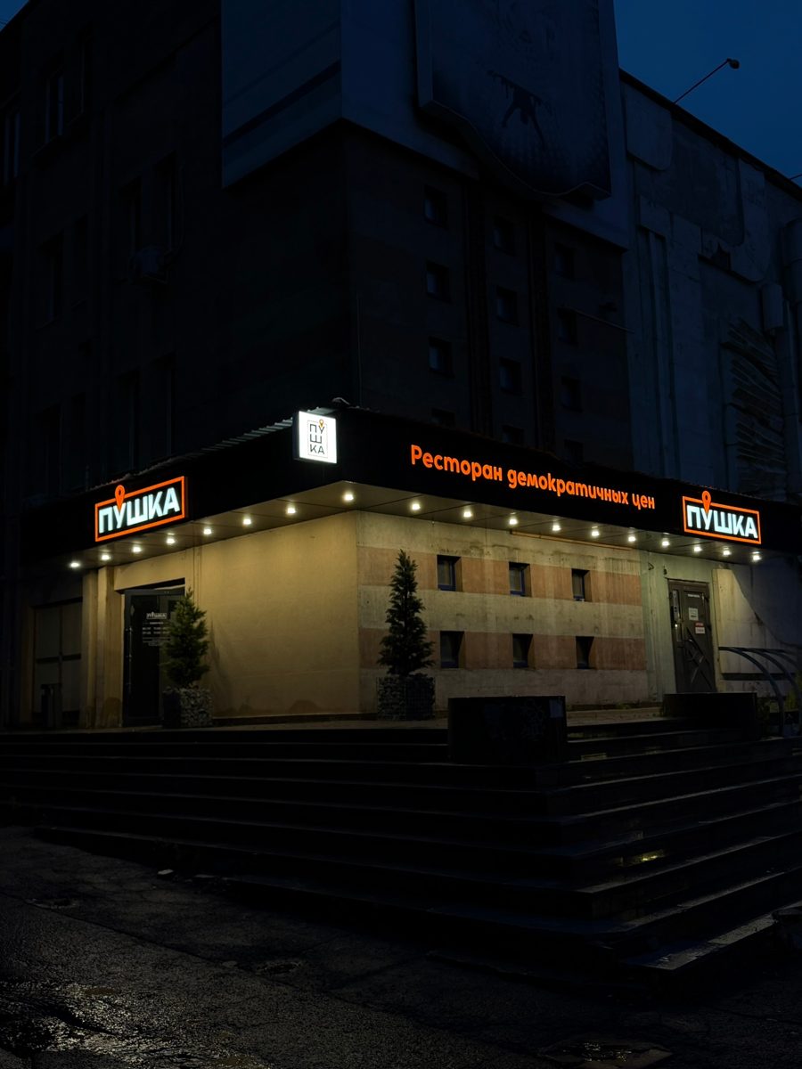 Световые буквы «Пушка» на угловом фасаде ресторана вечером